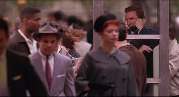 Movie still from “Quiz Show” (1994), directed by Robert Redford – A group of people standing around each other in a room; Medium shot, High angle