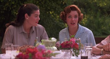 Movie still from “Quiz Show” (1994), directed by Robert Redford – Two women sitting at a table with flowers in front of them; Medium shot, Over the shoulder angle