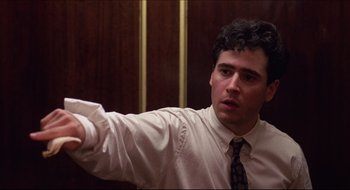 Movie still from “Quiz Show” (1994), directed by Robert Redford – A man in a white shirt and tie holding a wii controller; Close Up shot, Low angle