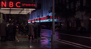 Movie still from “Quiz Show” (1994), directed by Robert Redford – A group of people standing on the side of the street; Wide shot, High angle