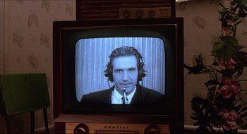 Movie still from “Quiz Show” (1994), directed by Robert Redford – A man wearing headphones on a television; Close Up shot, Over the shoulder angle