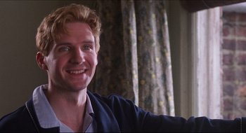 Movie still from “Quiz Show” (1994), directed by Robert Redford – A person smiling for the camera; Close Up shot, Over the shoulder angle
