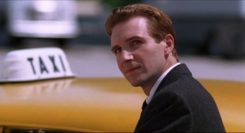 Movie still from “Quiz Show” (1994), directed by Robert Redford – A person wearing a suit near a car; Close Up shot, Low angle