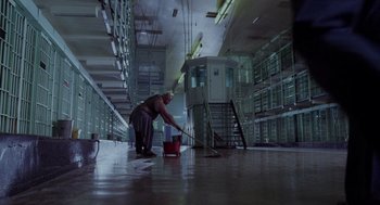 Movie still from “Raising Arizona” (1987), directed by Joel Coen – A man mopping the floor in a building; Wide shot, High angle