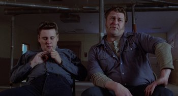 Movie still from “Raising Arizona” (1987), directed by Joel Coen – Two men sitting next to each other in a room; Medium shot, Low angle