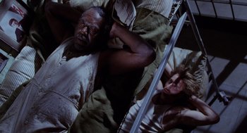 Movie still from “Raising Arizona” (1987), directed by Joel Coen – A man laying in a bed next to a woman; Medium shot, Overhead angle