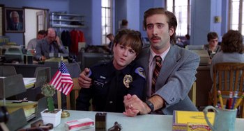 Movie still from “Raising Arizona” (1987), directed by Joel Coen – A man and a woman sitting next to each other at a table; Medium shot, Low angle