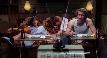 Movie still from “Raising Arizona” (1987), directed by Joel Coen – A man and a woman sitting at a table in front of each other; Medium shot, Low angle