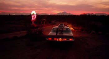 Movie still from “Raising Arizona” (1987), directed by Joel Coen – A car parked in the middle of a dirt road; Extreme Wide shot, Low angle