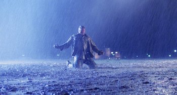 Movie still from “Raising Arizona” (1987), directed by Joel Coen – A man and a dog in the middle of a rain storm; Wide shot, Low angle