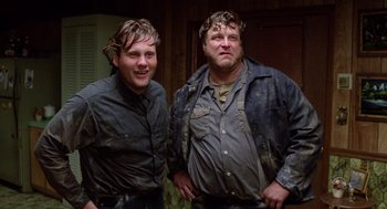 Movie still from “Raising Arizona” (1987), directed by Joel Coen – A couple of men standing next to each other; Medium shot, Low angle