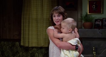 Movie still from “Raising Arizona” (1987), directed by Joel Coen – A woman holding a baby in her arms; Medium shot, Over the shoulder angle