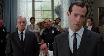 Movie still from “Raising Arizona” (1987), directed by Joel Coen – A group of men standing in a room; Close Up shot, Low angle