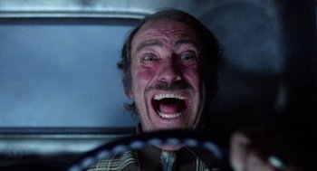 Movie still from “Raising Arizona” (1987), directed by Joel Coen – An old man with a beard and a tie is smiling; Close Up shot, Low angle