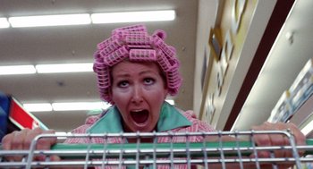 Movie still from “Raising Arizona” (1987), directed by Joel Coen – A woman with a pink hair curlers on her head; Close Up shot, Low angle