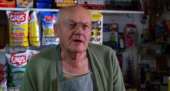 Movie still from “Raising Arizona” (1987), directed by Joel Coen – An older man wearing an apron in a store; Close Up shot, Low angle