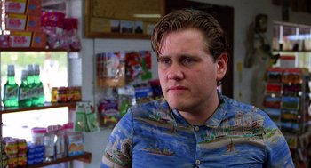 Movie still from “Raising Arizona” (1987), directed by Joel Coen – A young man in a blue shirt is looking at the camera; Close Up shot, Low angle