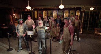 Movie still from “Raising Arizona” (1987), directed by Joel Coen – A group of men standing in front of a building; Wide shot, Low angle