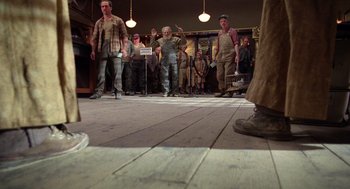 Movie still from “Raising Arizona” (1987), directed by Joel Coen – A group of men standing on a wooden floor; Wide shot, Low angle