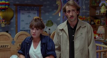 Movie still from “Raising Arizona” (1987), directed by Joel Coen – A man and a woman standing next to each other; Medium shot, Over the shoulder angle