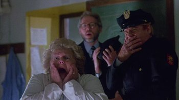 Movie still from “Re-Animator” (1985), directed by Stuart Gordon – An older woman and two older men in a room; Close Up shot, Low angle