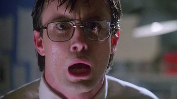 Movie still from “Re-Animator” (1985), directed by Stuart Gordon – A person wearing glasses; Close Up shot, Low angle