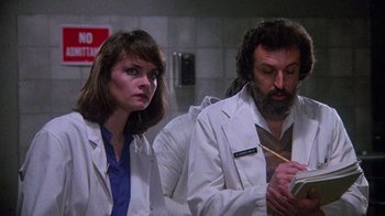 Movie still from “Re-Animator” (1985), directed by Stuart Gordon – A man and a woman wearing lab coats; Close Up shot, Low angle