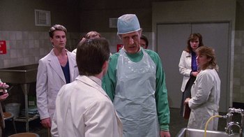 Movie still from “Re-Animator” (1985), directed by Stuart Gordon – A group of people standing in a room; Medium shot, Over the shoulder angle