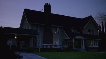 Movie still from “Re-Animator” (1985), directed by Stuart Gordon – A house that is lit up at night time; Extreme Wide shot, Low angle
