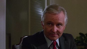 Movie still from “Re-Animator” (1985), directed by Stuart Gordon – An older man wearing a suit and red tie; Close Up shot, Low angle