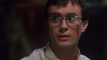 Movie still from “Re-Animator” (1985), directed by Stuart Gordon – A person wearing glasses with blood on his face; Close Up shot, Low angle