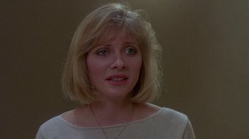 Movie still from “Re-Animator” (1985), directed by Stuart Gordon – A person wearing a necklace; Close Up shot, Over the shoulder angle