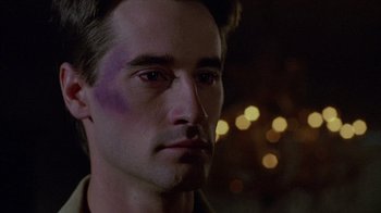 Movie still from “Re-Animator” (1985), directed by Stuart Gordon – A person with a bruise on his face; Close Up shot, Over the shoulder angle