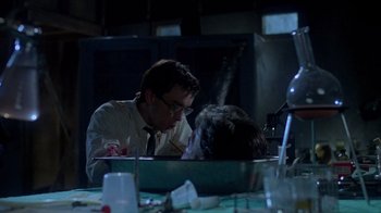 Movie still from “Re-Animator” (1985), directed by Stuart Gordon – A man and a woman sitting at a dinner table; Medium shot, Over the shoulder angle