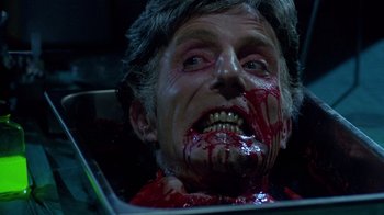 Movie still from “Re-Animator” (1985), directed by Stuart Gordon – A person with blood on his face; Close Up shot, Over the shoulder angle