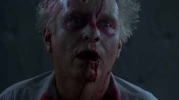 Movie still from “Re-Animator” (1985), directed by Stuart Gordon – A person with blood on his face; Close Up shot, Low angle