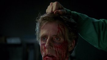 Movie still from “Re-Animator” (1985), directed by Stuart Gordon – A man with blood all over his face and head; Close Up shot, Over the shoulder angle