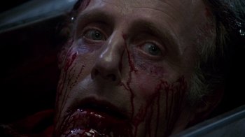 Movie still from “Re-Animator” (1985), directed by Stuart Gordon – A person with blood on his face; Close Up shot, High angle