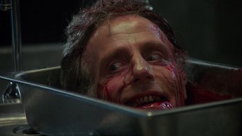 Movie still from “Re-Animator” (1985), directed by Stuart Gordon – A person with blood on his face; Close Up shot, Low angle