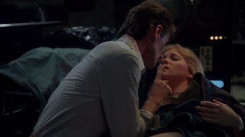 Movie still from “Re-Animator” (1985), directed by Stuart Gordon – A man and a woman kissing on a bed; Close Up shot, High angle