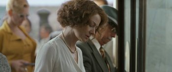 Movie still from “Reaching for the Moon” (2013), directed by Bruno Barreto – A woman in a white blouse and a man in a suit and tie; Close Up shot, Over the shoulder angle