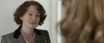 Movie still from “Reaching for the Moon” (2013), directed by Bruno Barreto – A person in a mirror wearing a suit; Close Up shot, Over the shoulder angle