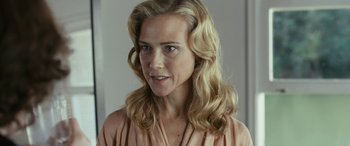 Movie still from “Reaching for the Moon” (2013), directed by Bruno Barreto – A woman with blonde curly hair wearing a pink shirt; Close Up shot, Over the shoulder angle