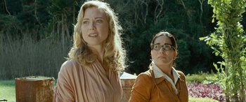 Movie still from “Reaching for the Moon” (2013), directed by Bruno Barreto – Two women standing next to each other in front of trees; Close Up shot, Low angle