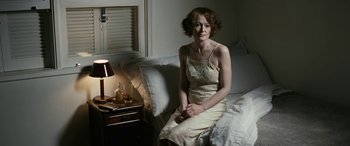 Movie still from “Reaching for the Moon” (2013), directed by Bruno Barreto – A woman sitting on the edge of a bed in a bedroom; Medium shot, High angle