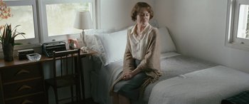 Movie still from “Reaching for the Moon” (2013), directed by Bruno Barreto – An older woman sitting on a bed in a room; Medium shot, High angle