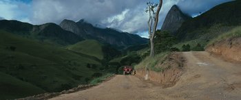 Movie still from “Reaching for the Moon” (2013), directed by Bruno Barreto – A truck driving down a dirt road in the mountains; Extreme Wide shot, High angle