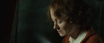 Movie still from “Reaching for the Moon” (2013), directed by Bruno Barreto – A woman's face in a dark room; Close Up shot, Over the shoulder angle