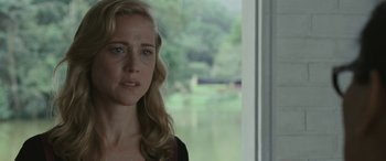 Movie still from “Reaching for the Moon” (2013), directed by Bruno Barreto – A woman standing in front of a window looking sad; Close Up shot, Over the shoulder angle