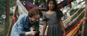 Movie still from “Reaching for the Moon” (2013), directed by Bruno Barreto – A woman taking a picture of a girl with a camera; Close Up shot, Over the shoulder angle